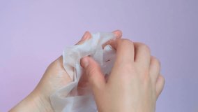 Female hand holding white sheet of moisturizing mask close-up on purple background. - Powered by Shutterstock - Get 15% off with code: PIKWIZARD15