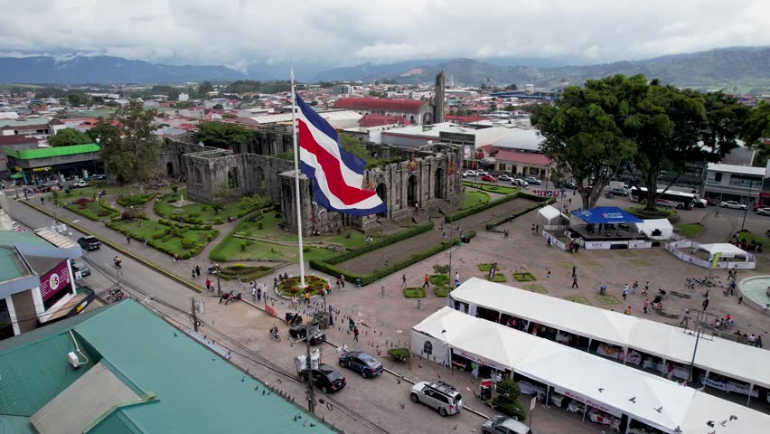 Beautiful View of the Costa Rica Flag with the Bicentennial Angel in Cartago, next to the Ruins and the basilica - Costa Rica Patriotic Symbols