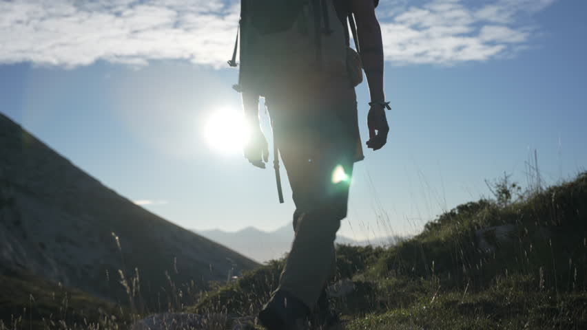 A mountaineer ascends to the top of the mountain step by step with the sun in the background backlit in a beautiful sunrise enjoying the first hours of light of a summer day in the Pyrenees Royalty-Free Stock Footage #1109201411
