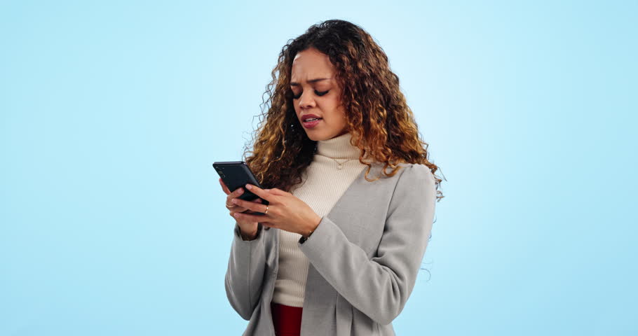 Phone, angry typing and woman in studio for business contact, problem and social media comments. Networking, negotiation feedback and spam, frustrated businesswoman with smartphone on blue background Royalty-Free Stock Footage #1109202547