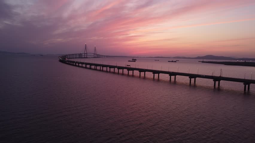 Sunset, red sky splashing on the bridge over the sea