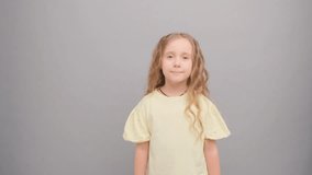 A little girl in a yellow T-shirt is jumping in the studio on a gray background. - Powered by Shutterstock - Get 15% off with code: PIKWIZARD15