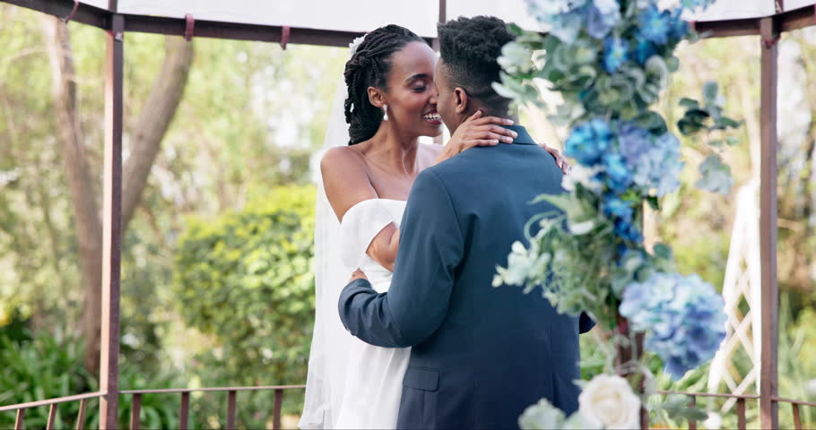 Black couple, wedding and kiss for love, marriage or commitment in embrace or hug together. Married African woman and man kissing affection, trust or relationship of bride or groom in outdoor romance