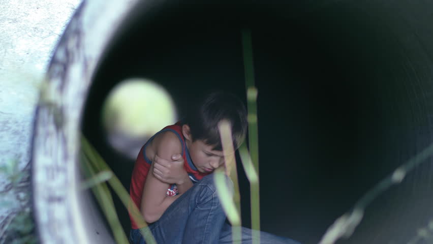 Resilient Exploration: Boy Seeking Warmth and Shelter Inside Urban Pipe Royalty-Free Stock Footage #1109210543