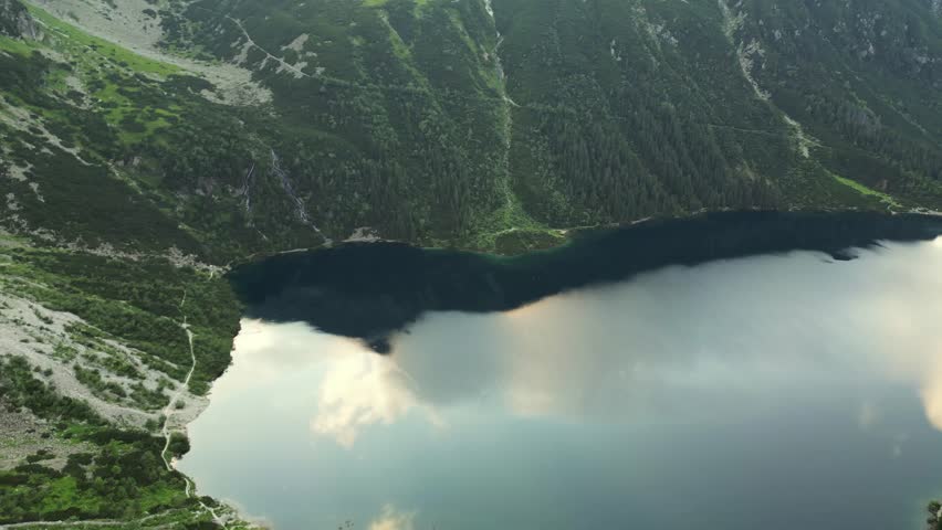 Flying High Above the Water and a Sea of Fog at Sunrise over the mountains. Morskie Oko lake in Tatra Mountains. Flying over the clouds. Lush Scenery and Magnificent Mountain Range With two lakes