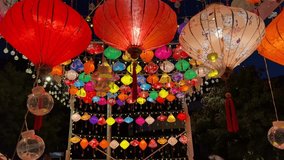 Colorful 4K Video. Multicolored Chinese lanterns glow with multi-colored lights at night. View from below. Concept of oriental holiday, Asian mood, Chinese New Year. Stage decoration for performances