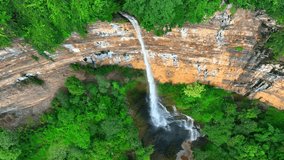 Aerial view of majestic waterfall cascading from towering forest cliff, captured by a drone, nature's breathtaking spectacle. (Nam Nao Canyon, Nam Nao National Park, Thailand). Drone.
