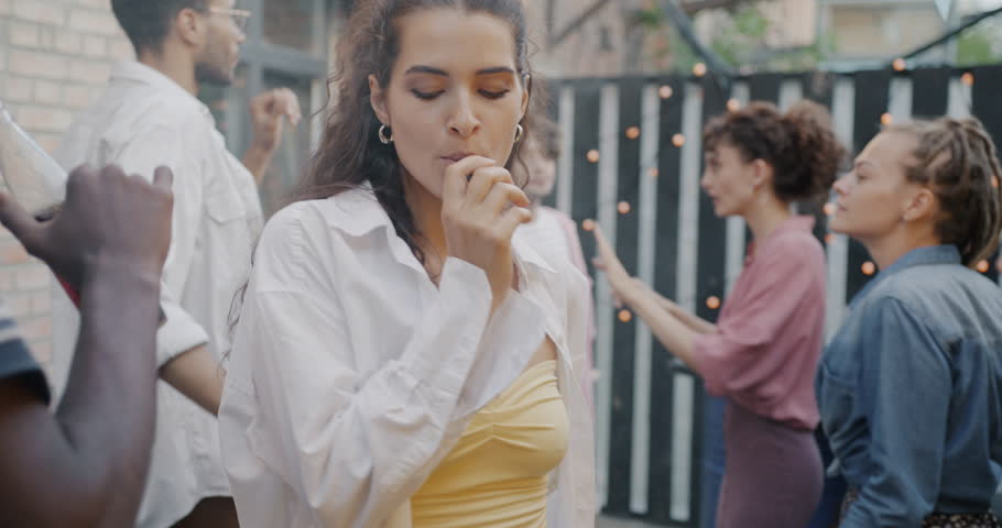 Portrait of stylish young woman dancing and vaping enjoying modern party with friends outdoors. Electronic cigarette and bad habit concept. | Shutterstock HD Video #1109226689