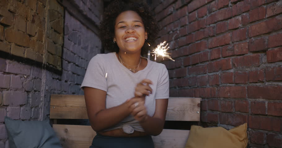 Portrait of excited African American girl dancing holding sparkler enjoying evening in loft style street cafe. Entertainment and youth culture concept. | Shutterstock HD Video #1109226693