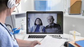online medical consultation, young female doctor with a headset communicates with elderly patients via video link while sitting in a hospital office
