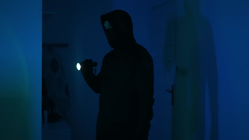 Masked robber with flashlight torch checking apartment. Royalty-Free Stock Footage #1109227747