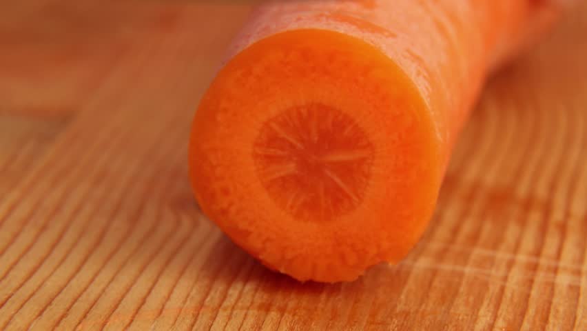 Cutting carrots with a knife on a wooden table. ASMR video of cutting vegetables. Round carrot pieces. Royalty-Free Stock Footage #1109230043