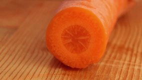 Cutting carrots with a knife on a wooden table. ASMR video of cutting vegetables. Round carrot pieces.