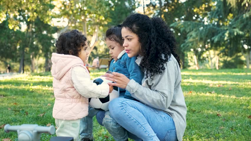 Dominican mother easing sibling rivalry teaching her kids to share the soccer ball. Royalty-Free Stock Footage #1109232809