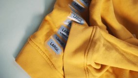 Vertical video of top view of lighting yellow large sweater on blue background