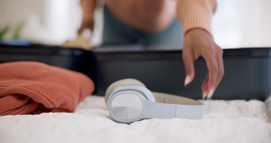 Getting ready, bedroom and a woman with music and suitcase for vacation packing. Home, happy and a young girl with headphones for audio and luggage on a holiday for travel, relax or streaming