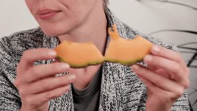 A middle-aged woman eats a melon. Proper nutrition, eating fruits, vegetarian diet