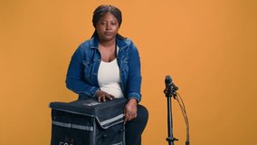 Enthusiastic black woman using bicycle for on-demand delivering of local fruits. Friendly delivery person providing fast-paced courier service of delicious vegetables in basket. - Powered by Shutterstock - Get 15% off with code: PIKWIZARD15