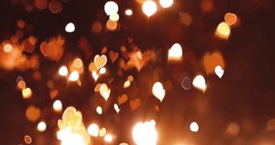 Glowing heart with bokeh effect on black background. Romantic Abstract Motion Background. Valentine's Day, Festival Event, Wedding, Confetti, Christmas, Diwali, Celebration, New Year.