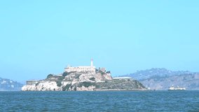 4K HD video zooming in on Alcatraz Island, 1.25 miles away from San Francisco on a sunny day. The islands facilities are managed by the National Park Service and it is open to the public for tours.