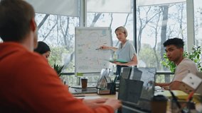 Coach woman telling flipchart meeting in panoramic windows room. Successful businesswoman pointing hand to whiteboard in modern office. Female corporate supervisor making presentation for colleagues  - Powered by Shutterstock - Get 15% off with code: PIKWIZARD15