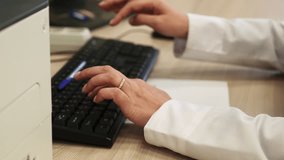 Close up of female hands typing on computer keyboard at the office. Clip. Young woman using computer.