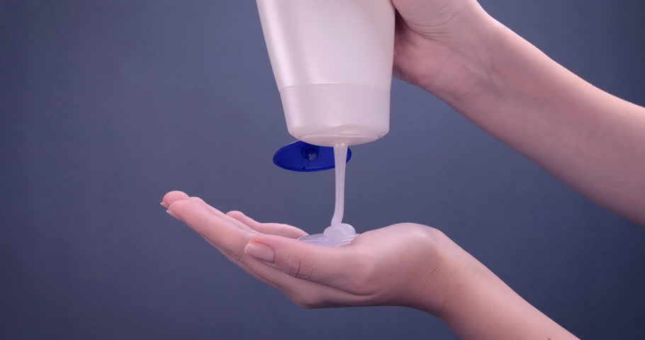 Shower gel in white bottle poured into woman palm. Concept of skin feeling fresh, clean and revitalized with the body wash. Skincare, wellness, hygiene concept. Slow motion 4k