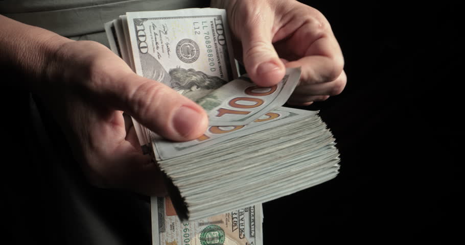 Male hands count dollar bills. Banker counts money cash manually. Registration of large loan. Recalculation of monthly salary, annual savings. Investments in large companies, purchase of shares.