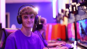 video portrait of young gamer boy ready to play online with his headset and neon blurred background