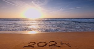 Sea sunrise and welcoming new year 2024 text written on the beach shore sand as nature background