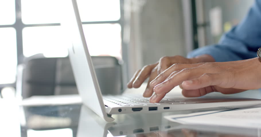 African american casual businessman at desk using laptop and drinking coffee at home, slow motion. Communication, home office, remote working and casual business, unaltered. | Shutterstock HD Video #1109275629