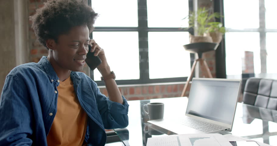 Happy african american casual businessman talking on smartphone at home, copy space, slow motion. Communication, home office, remote working and casual business, unaltered. | Shutterstock HD Video #1109276257