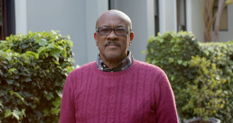 Portrait of happy senior african american man in glasses laughing in sunny garden, slow motion. Retirement, wellbeing and senior lifestyle, unaltered. | Shutterstock HD Video #1109276425