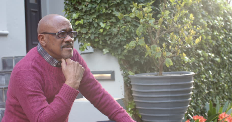 Happy senior african american man in glasses sitting and laughing in garden, slow motion. Retirement, wellbeing, relaxation and senior lifestyle, unaltered. | Shutterstock HD Video #1109276479