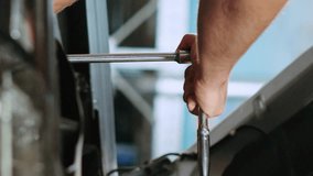 Vertical video Close up shot on torque wrench used by certified mechanic in car service to tighten bolts after fixing vehicle parts. Repairman utilizing professional tools to repair automobile - Powered by Shutterstock - Get 15% off with code: PIKWIZARD15