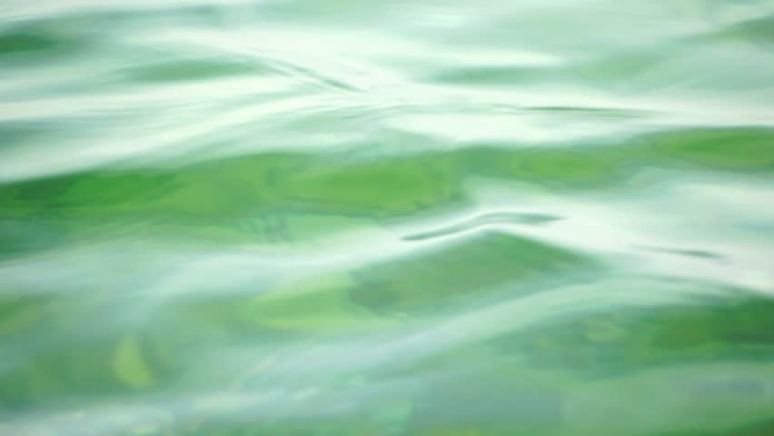 Sea water surface. Low angle view over clear azure sea water. Sun glare. Abstract nautical summer ocean nature. Holiday, vacation and travel concept. Nobody. Slow motion. Weather and climate change