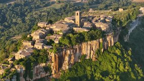 Aerial summer sunrise view of famous Civita di Bagnoregio village, located on top of a volcanic tuff hill overlooking the Tiber river valley, province of Viterbo, Lazio, Italy