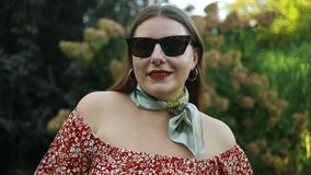 Slow motion of happy Caucasian 30s woman in sunglasses dancing singing outdoors in city street having fun alone. High quality FullHD footage