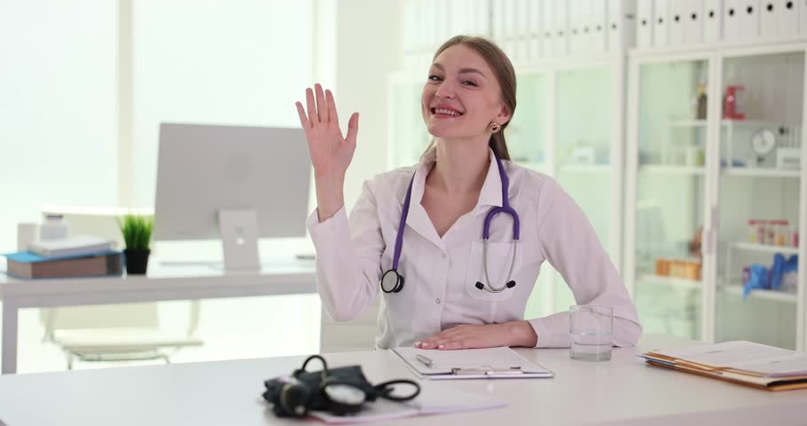 Portrait of smiling doctor looking at camera and waving at camera. Medical therapist consults remotely at virtual online meeting with patient Royalty-Free Stock Footage #1109290451