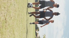 Video of happy diverse boys playing soccer on sports field. primary school education, sport and exercising.