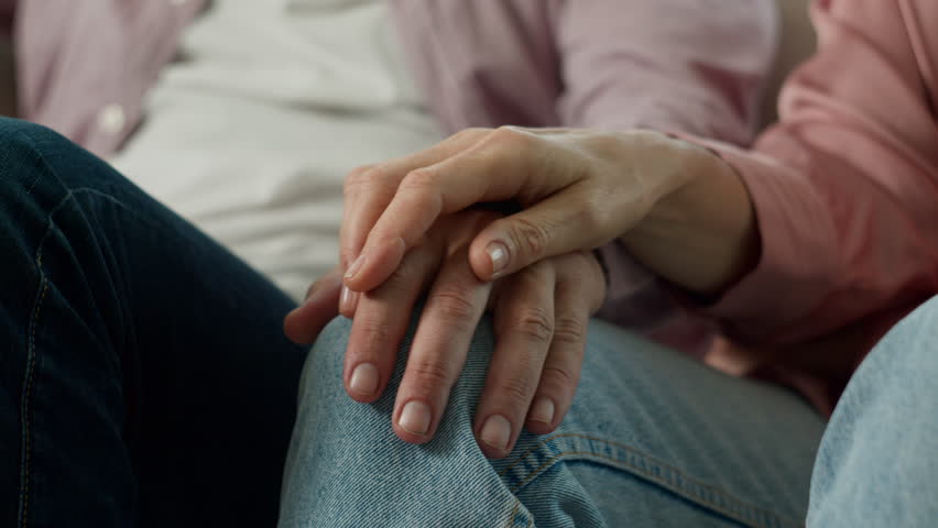 Close-up unrecognizable elderly old people holding hands with wrinkles mature married couple man woman pensioners loving senior husband wife feeling love caring support happy together in relationship