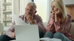 Worried senior caucasian married couple man woman checking bills bank loan payment learn documents discuss unpaid debt taxes stressed elderly grandparents looking at laptop upset about money problem - Powered by Shutterstock - Get 15% off with code: PIKWIZARD15
