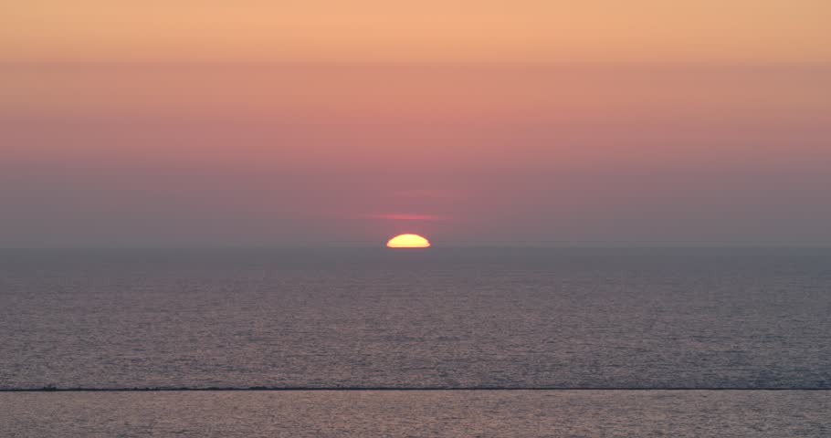 Sun rising out of Lake Michigan on the Autumn Equinox 2023. Gentle wash of dusky purple to warm orange