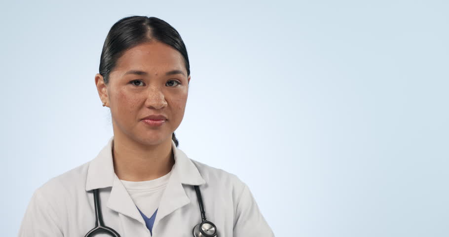 Doctor face, happy asian woman and pointing at healthcare commercial, hospital medicine promo or clinic studio notification. Medical portrait, mockup space and nurse presentation on blue background