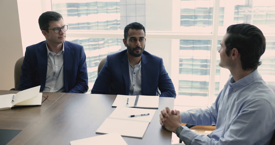 Three multi-ethnic businessmen negotiate together in boardroom, make profitable commercial deal, shake hands express respect after effective formal meeting. Trust, legal commitment, business etiquette Royalty-Free Stock Footage #1109316773