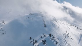 Ski hill on sunny winter day with scenic cloud. Skiers and snowboarders skiing on snow slopes with ski lift. Aerial drone footage of skiers and snowboarders on Mammoth lakes resort with snowy mountain - Powered by Shutterstock - Get 15% off with code: PIKWIZARD15
