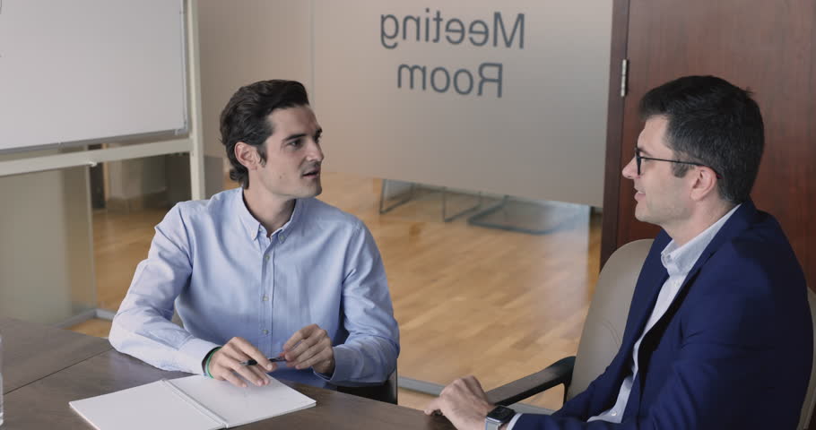 Hispanic HR manager interviewing 45s middle-aged job applicant in boardroom, candidate answer questions looks confident. Successful businessman having formal conversation negotiating in meeting room | Shutterstock HD Video #1109318365