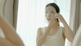 Beautiful young asian woman applying sheet facial mask and looking mirror at home, Girl applying cosmetic and makeup with skincare face for wrinkle, treatment and moisturizer, health and wellness - Powered by Shutterstock - Get 15% off with code: PIKWIZARD15