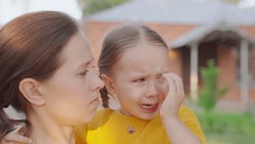 Loving young mother hugs, soothes her crying little daughter. Child is crying in park in arms of mom. Mommy soothes baby. Family mother, child with tears in their eyes hugs their mother, emotionally. - Powered by Shutterstock - Get 15% off with code: PIKWIZARD15