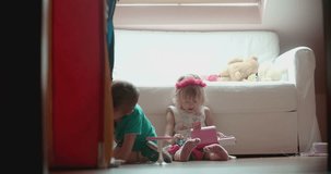 Cute little boy and girl playing in their room with toys. Shoot on Digital Cinema Camera in 4K - ProRes 422 codec.